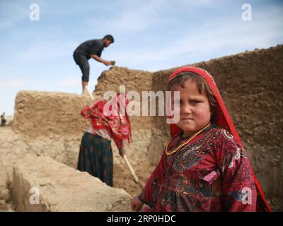 (180515) -- MAZAR-i-SHARIF, le 15 mai 2018 -- Une enfant afghane déplacée pose pour des photos alors que son parent fait un mur de boue dans un camp de fortune à Mazar-i-Sharif, capitale de la province septentrionale de Balkh, Afghanistan, le 20 avril 2018. Les conflits endémiques en Afghanistan ont entraîné le déplacement de 83 345 000 personnes, dont des femmes et des enfants, depuis le début de 2018, selon un rapport du Bureau de la coordination des affaires humanitaires des Nations Unies. POUR ALLER AVEC L'ARTICLE : enfants socialement vulnérables qui portent le poids de la guerre en Afghanistan ) (dtf) AFGHANISTAN-BALKH-ENFANTS DÉPLACÉS RahmatxAlizadah PUBLIC Banque D'Images