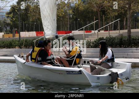 (180520) -- ATHÈNES, 20 mai 2018 -- les gens apprennent à naviguer dans le canal du Centre culturel de la Fondation Stavros Niarchos (SNFCC) à Athènes, Grèce, le 19 mai 2018. La SNFCC propose des activités de plein air pour que le public puisse profiter des vastes espaces ouverts.) (hy) GRÈCE-ATHÈNES-LEÇONS DE VOILE-SNFCC MariosxLolos PUBLICATIONxNOTxINxCHN Banque D'Images