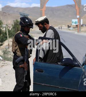 (180523) -- GHAZNI, 23 mai 2018 -- un membre de la sécurité afghane perquisitionne un homme à un poste de contrôle après les attaques des talibans sur les districts de Dih Yak et Jaghato dans la ville de Ghazni, capitale de la province de Ghazni, Afghanistan, le 22 mai 2018. Au moins 12 membres de la police, dont deux officiers supérieurs de la police, ont été tués dans de nouveaux affrontements avec des militants talibans dans la province de Ghazni, dans l'est de l'Afghanistan, a déclaré mardi un responsable local. AFGHANISTAN-GHAZNI-TALIBAN ATTAQUE-POSTES DE CONTRÔLE SayedxMominzadah PUBLICATIONxNOTxINxCHN Banque D'Images