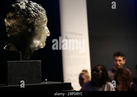 (180524) -- ATHÈNES, 24 mai 2018 -- les visiteurs regardent une tête de bronze d'une statue sur les innombrables aspects de la beauté dans l'art ancien au Musée archéologique national d'Athènes, Grèce, le 23 mai 2018. L'exposition temporaire est conçue pour commémorer le 150e anniversaire du musée. ) GRÈCE-ATHÈNES-EXPOSITION D'ART ANTIQUE MariosxLolos PUBLICATIONxNOTxINxCHN Banque D'Images