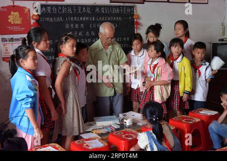 (180524) -- NANCHANG, 24 mai 2018 -- Miao Yanxiang récompense les enfants qui réussissent bien leurs devoirs avec des prix qu'il a achetés au poste de soins pour enfants laissés-pour-compte à son domicile de Shibu Town, ville de Nanchang dans la province de Jiangxi dans l'est de la Chine, le 23 mai 2018. Miao, âgé de plus de 70 ans, a créé un poste de garde pour les enfants laissés derrière lui dans sa propre maison en 2009, où il a fourni une place gratuite pour les enfants pour faire leurs devoirs et étudier après l'école. Ayant reçu plus de 3 000 enfants au cours des neuf dernières années, Miao est satisfait de son travail bénévole et voit les progrès des enfants. (ZWX) CHINE-JIANGXI-GAUCHE Banque D'Images