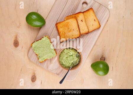 Toast de pain de grains entiers avec de la tartinade à l'avocat. Vue du dessus de la table en bois. Banque D'Images