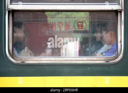 (180529) -- XI AN, le 29 mai 2018 -- des étudiants sont assis à l'intérieur des wagons spéciaux pour étudiants du train n° 6063 en Chine, le 27 mai 2018. Le train n° 6063, qui relie 38 stations le long de la route entre Baoji dans la province du Shaanxi et Guangyuan dans la province du Sichuan, dessert des milliers d'élèves qui vivent dans des zones montagneuses et qui doivent se rendre de l'école à la maison chaque semaine. Pour améliorer les services aux passagers étudiants, des voitures spéciales pour étudiants équipées de bureaux plus grands et d'une bibliothèque ont été mises en service à la fin de 2017. À l approche de la Journée internationale de l enfance de cette année, plus de 300 nouveaux livres Banque D'Images