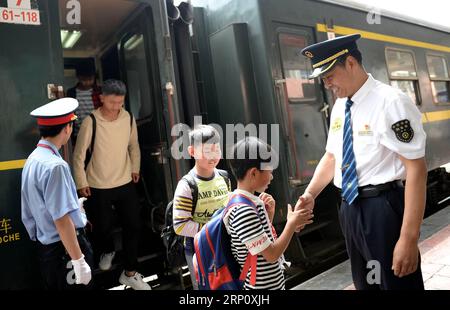 (180529) -- XI AN, 29 mai 2018 -- les étudiants descendent et disent au revoir à Xiang Baolin, chef du train n° 6063, à la gare de Lueyang, dans la province du Shaanxi, au nord-ouest de la Chine, le 27 mai 2018. Le train n° 6063, qui relie 38 stations le long de la route entre Baoji dans la province du Shaanxi et Guangyuan dans la province du Sichuan, dessert des milliers d'élèves qui vivent dans des zones montagneuses et qui doivent se rendre de l'école à la maison chaque semaine. Pour améliorer les services aux passagers étudiants, des voitures spéciales pour étudiants équipées de bureaux plus grands et d'une bibliothèque ont été mises en service à la fin de 2017. Avec le point d'accès Banque D'Images