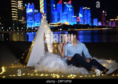 (180601) -- QINGDAO, 1 juin 2018 -- un couple pose pour des photos sur une plage de Qingdao, ville hôte du 18e Sommet de l Organisation de coopération de Shanghai (OCS), dans la province du Shandong de l est de la Chine, le 3 mai 2018. (lmm) CHINE-QINGDAO-SCO-VILLE-COUPLES-PHOTO-ROMANCE (CN) LixZiheng PUBLICATIONxNOTxINxCHN Banque D'Images