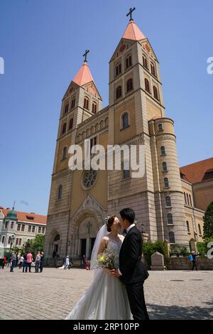 (180601) -- QINGDAO, 1 juin 2018 -- un couple pose pour des photos devant une cathédrale à Qingdao, ville hôte du 18e Sommet de l'Organisation de coopération de Shanghai (OCS), dans la province du Shandong de l'est de la Chine, le 23 mai 2018. ) (lmm) CHINA-QINGDAO-SCO-CITY-COUPLES-PHOTO-ROMANCE (CN) ZhangxCheng PUBLICATIONxNOTxINxCHN Banque D'Images