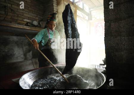 (180609) -- DANZHAI, le 9 juin 2018 -- Une femme du groupe ethnique miao fabrique des produits batik dans la ville de Yangwu, dans le comté de Danzhai, dans le sud-ouest de la Chine, dans la province du Guizhou, le 8 juin 2018. L artisanat batik du peuple Miao est l un des patrimoines intangibles nationaux de la Chine. En tant que principal site d'héritage de l'artisanat batik du peuple Miao, le village de Jijia Miao de la ville de Yangwu a un bon nombre d'excellents artisans, mais le trafic gênant avait entravé la vente de produits batik à l'extérieur avant 2017. Avec l'amélioration croissante de la circulation et de l'aide du gouvernement local et des bénévoles depuis 2017, les gens Banque D'Images