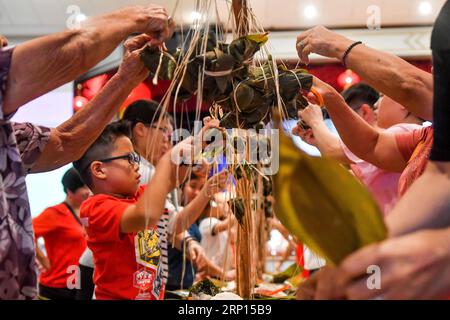 (180610) -- KUALA LUMPUR, le 10 juin 2018 -- les concurrents fabriquent Zongzi, une boulette en forme de pyramide faite de riz gluant enveloppé dans des feuilles de bambou ou de roseau, lors d'un concours pour célébrer le prochain festival des bateaux-dragons à Kuala Lumpur, Malaisie, le 10 juin 2018. )(cl) MALAYSIA-KUALA LUMPUR-ZONGZI-WRAPPING-CONTEST ChongxVoonxChung PUBLICATIONxNOTxINxCHN Banque D'Images