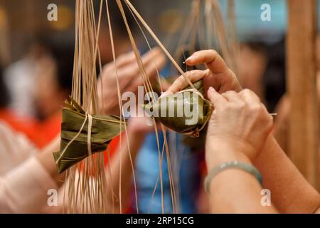 (180610) -- KUALA LUMPUR, le 10 juin 2018 -- les concurrents fabriquent Zongzi, une boulette en forme de pyramide faite de riz gluant enveloppé dans des feuilles de bambou ou de roseau, lors d'un concours pour célébrer le prochain festival des bateaux-dragons à Kuala Lumpur, Malaisie, le 10 juin 2018. )(cl) MALAYSIA-KUALA LUMPUR-ZONGZI-WRAPPING-CONTEST ChongxVoonxChung PUBLICATIONxNOTxINxCHN Banque D'Images