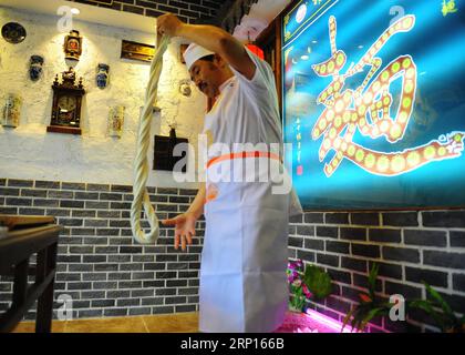 (180612) -- PÉKIN, 12 juin 2018 -- Quan Fujian tire des nouilles dans son restaurant de la ville de Yantai, dans la province du Shandong de l est de la Chine, le 7 juin 2018. La nouille Fushan est un plat traditionnel populaire dans la province du Shandong. Les nouilles sont tirées à la main et cuites avec diverses sauces et bouillons. La fabrication des nouilles Fushan a été inscrite au patrimoine culturel immatériel provincial du Shandong en 2013. (wsw) CHINE-SHANDONG-FABRICATION DE NOUILLES (CN) RenxPengfei PUBLICATIONxNOTxINxCHN Banque D'Images