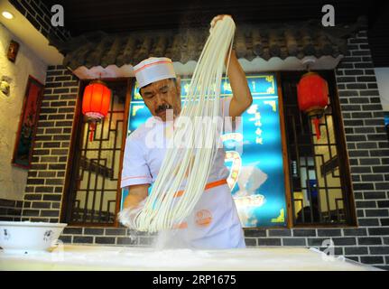 (180612) -- PÉKIN, 12 juin 2018 -- Quan Fujian tire des nouilles dans son restaurant de la ville de Yantai, dans la province du Shandong de l est de la Chine, le 7 juin 2018. La nouille Fushan est un plat traditionnel populaire dans la province du Shandong. Les nouilles sont tirées à la main et cuites avec diverses sauces et bouillons. La fabrication des nouilles Fushan a été inscrite au patrimoine culturel immatériel provincial du Shandong en 2013. (wsw) CHINE-SHANDONG-FABRICATION DE NOUILLES (CN) RenxPengfei PUBLICATIONxNOTxINxCHN Banque D'Images