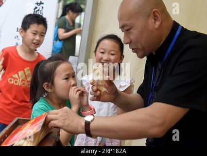 (180616) -- BEIJING, 16 juin 2018 -- Une fille apprend à faire du soufflage de figure de sucre lors d'une activité pour célébrer le prochain festival des bateaux-dragons au Beijing Stone Carving Art Museum à Beijing, capitale de la Chine, le 16 juin 2018.) (Wyo) CHINA-DRAGON BOAT FESTIVAL-CELEBRATIONS (CN) LuoxXiaoguang PUBLICATIONxNOTxINxCHN Banque D'Images