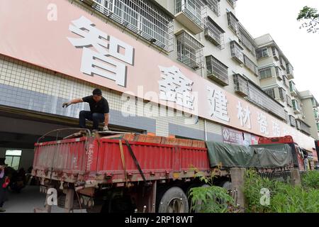 (180618) -- NANCHANG, 18 juin 2018 -- Zou Yujiang se prépare à décharger des marchandises sur un marché de matériaux de construction dans le comté de Changting, dans la province du Fujian du sud-est de la Chine, le 13 juin 2018. Zou Yujiang, 41 ans, est chauffeur de camion de la ville de Gao an de la province du Jiangxi. Il a passé la plupart de son temps sur la route, transportant des marchandises d'un endroit à un autre. Il y a eu plus de 21 millions d'employés dans l'industrie du transport routier de marchandises en Chine jusqu'à présent. Comme Zou Yujiang, la plupart d’entre eux gagnent leur vie sur des camions avec peu de temps en famille. Leurs efforts acharnés y ont contribué Banque D'Images