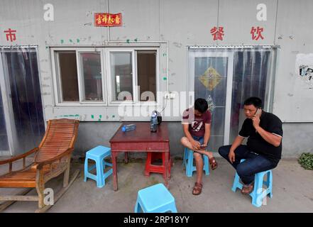 (180618) -- NANCHANG, le 18 juin 2018 -- Zou Yujiang (R) fait un appel d'affaires dans un restaurant le long de la route nationale 206, le 12 juin 2018. Zou Yujiang, 41 ans, est chauffeur de camion de la ville de Gao an de la province du Jiangxi. Il a passé la plupart de son temps sur la route, transportant des marchandises d'un endroit à un autre. Il y a eu plus de 21 millions d'employés dans l'industrie du transport routier de marchandises en Chine jusqu'à présent. Comme Zou Yujiang, la plupart d’entre eux gagnent leur vie sur des camions avec peu de temps en famille. Leur travail acharné a contribué à la rapidité et à la fiabilité des services de livraison du Banque D'Images