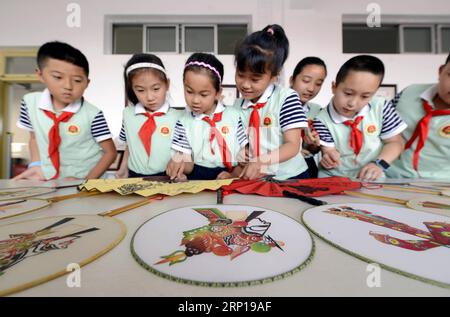 (180619) -- TANGSHAN, 19 juin 2018 -- des élèves regardent des fans sur le thème des marionnettes d'ombre à l'école primaire expérimentale n° 3 dans le comté de Laoting, province du Hebei, dans le nord de la Chine, le 19 juin 2018. Pour protéger et hériter de la culture traditionnelle, des cours sur la marionnette de l'ombre Laoting sont offerts dans de nombreuses écoles primaires locales. )(wsw) CHINA-HEBEI-SHADOW PUPPET-CLASS (CN) MuxYu PUBLICATIONxNOTxINxCHN Banque D'Images