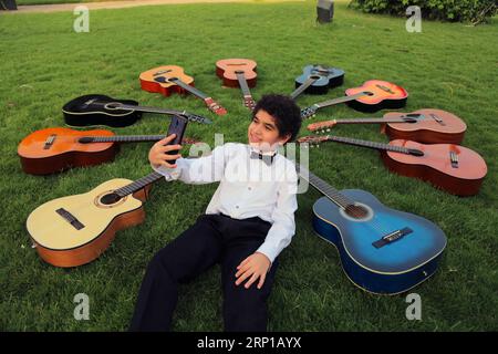(180621) -- LE CAIRE, 21 juin 2018 -- Un garçon prend des selfies avec des guitares lors d'un événement musical à l'occasion de la Journée mondiale de la musique au Caire, en Égypte, le 21 juin 2018. Journée mondiale de la musique ? est une célébration annuelle de la musique qui a lieu le 21 juin. ) ÉGYPTE-CAIRE-JOURNÉE MONDIALE DE LA MUSIQUE AhmedxGomaa PUBLICATIONxNOTxINxCHN Banque D'Images