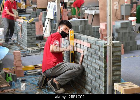 (180625) -- GUANGZHOU, 25 juin 2018 -- Un concurrent fait de la maçonnerie lors d'un essai du Concours ChinaSkills 2018 à Guangzhou, capitale de la province du Guangdong du sud de la Chine, le 25 juin 2018. Une série d’épreuves d’essai dans le Concours ChinaSkills 2018 a débuté lundi à Guangzhou. En organisant des épreuves d'essai à Guangzhou et Shanghai respectivement, le concours ChinaSkills 2018 sélectionnera des candidats qualifiés pour former l'équipe Chine pour le WorldSkills Kazan 2019. (Lb) CHINA-GUANGDONG-GUANGZHOU-CHINASKILLS-COMPETITION (CN) LiangxXu PUBLICATIONxNOTxINxCHN Banque D'Images