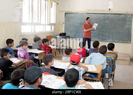 (180626) -- DAMAS, le 26 juin 2018 -- des enfants syriens suivent un cours dans une classe d'une école dans la campagne de la Ghouta orientale de la capitale Damas, anciennement tenue par les rebelles, le 25 juin 2018. Le gouvernement syrien a remis en état quelques écoles dans la Ghouta orientale après le retrait des rebelles de ces zones en avril dernier. Ces enfants sont sortis de l'école depuis longtemps et font maintenant l'objet d'un programme éducatif intensifié pour rattraper les années perdues d'éducation. ) (lrz) SYRIE-DAMAS-ENFANTS-RETOUR À L'ÉCOLE AmmarxSafarjalani PUBLICATIONxNOTxINxCHN Banque D'Images