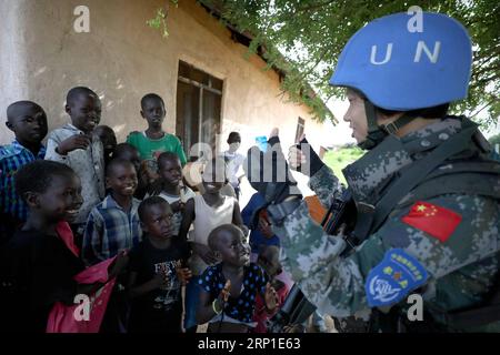 (180629) -- JUBA, le 29 juin 2018 -- le gardien chinois de la paix Yu Peijie (à droite) chante des chansons avec des enfants locaux à Juba, au Soudan du Sud, le 30 avril 2018. Yu Peijie, 26 ans, est le chef de l'unité de maintien de la paix féminine du bataillon d'infanterie de maintien de la paix chinois au Soudan du Sud. Elle a un surnom appelé Strong Elder Brother. Cependant, elle a aussi un cœur doux. Cette année marque le 70e anniversaire des opérations de maintien de la paix des Nations Unies. La Chine a commencé à participer aux opérations de maintien de la paix de l'ONU en 1990. Aujourd'hui, la Chine compte quelque 2 500 soldats de la paix et joue un rôle important dans la promotion et le maintien de la paix dans le monde. (d Banque D'Images