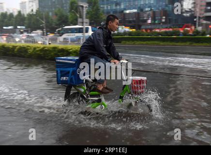 (180630) -- PÉKIN, 30 juin 2018 -- Un transporteur de nourriture fait son chemin le long d'une route inondée après une averse qui a frappé Pékin, capitale de la Chine, le 30 juin 2018.) (lmm) CHINA-BEIJING-WEATHER-DOWNPOUR (CN) LuoxXiaoguang PUBLICATIONxNOTxINxCHN Banque D'Images