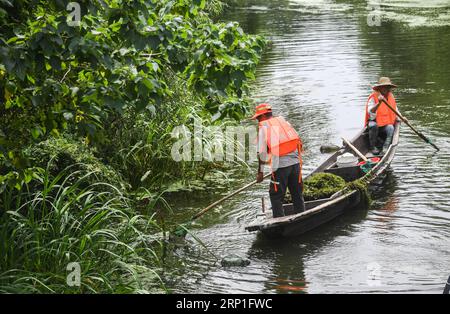 (180704) -- HUZHOU, 4 juillet 2018 -- des travailleurs nettoient des objets flottants sur une rivière dans la ville de Doling de la ville de Huzhou, province du Zhejiang dans l'est de la Chine, le 3 juillet 2018. La ville a récemment lancé un projet de nettoyage des rivières pour garantir l'eau potable et le bon fonctionnement des rivières rurales en été. (Sxk) CHINE-ZHEJIANG-HUZHOU-ENVIRONNEMENT RURAL (CN) XuxYu PUBLICATIONxNOTxINxCHN Banque D'Images