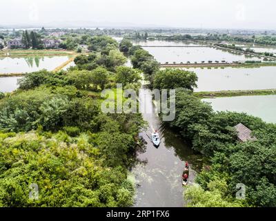 (180704) -- HUZHOU, 4 juillet 2018 -- sur cette photo aérienne, des ouvriers nettoient une rivière dans la ville de Doling de la ville de Huzhou, dans la province du Zhejiang de l'est de la Chine, le 3 juillet 2018. La ville a récemment lancé un projet de nettoyage des rivières pour garantir l'eau potable et le bon fonctionnement des rivières rurales en été. (Sxk) CHINE-ZHEJIANG-HUZHOU-ENVIRONNEMENT RURAL (CN) XuxYu PUBLICATIONxNOTxINxCHN Banque D'Images