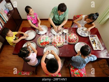 (180708) -- ZAOZHUANG, 8 juillet 2018 -- Wang Xin, successeur du patrimoine culturel immatériel, enseigne aux enfants à fabriquer des brioches cuites à la vapeur chez elle à Zaozhuang, dans la province du Shandong de l'est de la Chine, le 8 juillet 2018. Certains étudiants de Zaozhuang ont appris à faire des compétences de patrimoine culturel immatériel pour enrichir leurs vacances d'été. )(mcg) CHINE-SHANDONG-ZAOZHUANG-PATRIMOINE CULTUREL IMMATÉRIEL (CN) SunxZhongzhe PUBLICATIONxNOTxINxCHN Banque D'Images