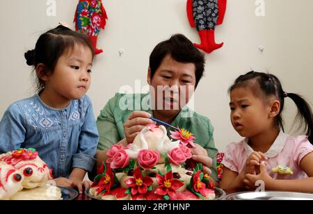 (180708) -- ZAOZHUANG, 8 juillet 2018 -- Wang Xin (C), successeur du patrimoine culturel immatériel, enseigne aux enfants à fabriquer des brioches cuites à la vapeur chez elle à Zaozhuang, dans la province du Shandong, dans l'est de la Chine, le 8 juillet 2018. Certains étudiants de Zaozhuang ont appris à faire des compétences de patrimoine culturel immatériel pour enrichir leurs vacances d'été. )(mcg) CHINE-SHANDONG-ZAOZHUANG-PATRIMOINE CULTUREL IMMATÉRIEL (CN) SunxZhongzhe PUBLICATIONxNOTxINxCHN Banque D'Images