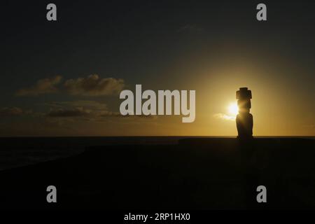 (180708) -- HANGA ROA, 8 juillet 2018 -- une photo prise le 7 juillet 2018 montre une vue d'une statue de pierre Moai au coucher du soleil sur l'île de Pâques au Chili. (dtf) CHILI-ÎLE DE PÂQUES-MOAI-COUCHER DE SOLEIL WangxPei PUBLICATIONxNOTxINxCHN Banque D'Images