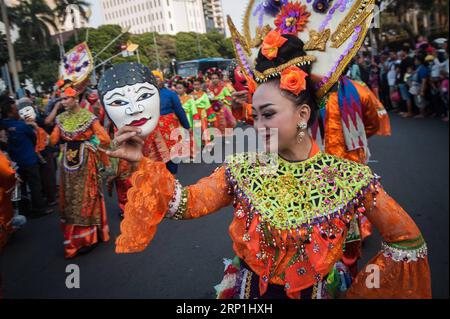 (180708) -- JAKARTA, le 8 juillet 2018 -- des participants en costumes traditionnels dansent dans une rue pendant le défilé culturel du Carnaval de Jakarta commémorant le 491e anniversaire de Jakarta, à Jakarta, Indonésie, le 8 juillet 2018.) (dtf) INDONÉSIE-JAKARTA-CARNAVAL-PARADE VerixSanovri PUBLICATIONxNOTxINxCHN Banque D'Images