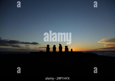 (180708) -- HANGA ROA, 8 juillet 2018 -- une photo prise le 7 juillet 2018 montre une vue de statues de pierre de Moai au coucher du soleil sur l'île de Pâques au Chili. (dtf) CHILI-ÎLE DE PÂQUES-MOAI-COUCHER DE SOLEIL WangxPei PUBLICATIONxNOTxINxCHN Banque D'Images