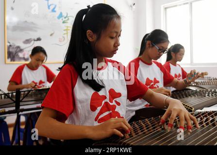 (180712) -- QINZHOU, 12 juillet 2018 -- des élèves apprennent à jouer de la cithare pendant un cours dans la ville de Qinzhou, dans la région autonome de Guangxi Zhuang, dans le sud de la Chine, le 12 juillet 2018. Les étudiants acquièrent de nouvelles compétences pendant leurs vacances d'été. )(wsw) CHINE-GUANGXI-VACANCES D'ÉTÉ (CN) ZhangxAilin PUBLICATIONxNOTxINxCHN Banque D'Images