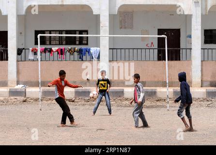 (180715) -- SANAA, 15 juillet 2018 -- des enfants yéménites déplacés à l'intérieur du pays qui ont fui leurs foyers à Hodeidah jouent au football dans un camp de déplacés à Sanaa, au Yémen, le 15 juillet 2018. Plus de 121 000 habitants ont fui la ville déchirée par la guerre de Hodeidah et d'autres parties de la province depuis juin 1, ont déclaré les Nations Unies cette semaine. YÉMEN-SANAA-PERSONNES DÉPLACÉES MohammedxMohammed PUBLICATIONxNOTxINxCHN Banque D'Images