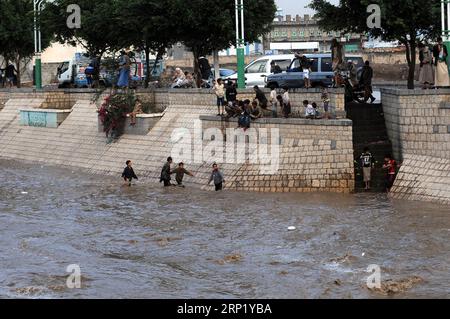 Actualités Bilder des Tages (180806) -- SANAA, 6 août 2018 -- des enfants jouent dans une zone inondée à Sanaa, Yémen, le 6 août 2018. De fortes pluies ont frappé Sanaa lundi après-midi, causant des inondations et des perturbations de la circulation à l'intérieur de la ville. YÉMEN-SANAA-PLUIE LOURDE MohammedxMohammed PUBLICATIONxNOTxINxCHN Banque D'Images