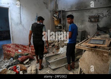 (180809) -- GAZA, 9 août 2018 -- des Palestiniens inspectent une maison endommagée où une mère enceinte et sa petite fille ont été tuées tandis que le père a été blessé après des frappes aériennes israéliennes, dans la ville de Deir el-Ballah, dans le centre de la bande de Gaza, le 9 août 2018. Israël a mené mercredi des frappes aériennes à grande échelle dans la bande de Gaza, ciblant 12 sites terroristes, a déclaré un porte-parole militaire dans un communiqué. Stringer) (dtf) MIDEAST-GAZA-AIRSTRIKE zhaoyue PUBLICATIONxNOTxINxCHN Banque D'Images