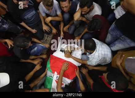 (180811) -- GAZA, 11 août 2018 -- des personnes en deuil et des proches se rassemblent autour du corps du palestinien Ali sa EED Aloul, 55 ans, lors de ses funérailles dans la ville de Rafah, dans le sud de la bande de Gaza, le 11 août 2018. Deux Palestiniens ont été tués et 242 blessés vendredi lors de manifestations et d'affrontements entre manifestants palestiniens et soldats israéliens dans l'est de la bande de Gaza, près de la frontière avec Israël, ont déclaré les médecins. (djj) MIDEAST-GAZA-FUNERAL KhaledxOmar PUBLICATIONxNOTxINxCHN Banque D'Images