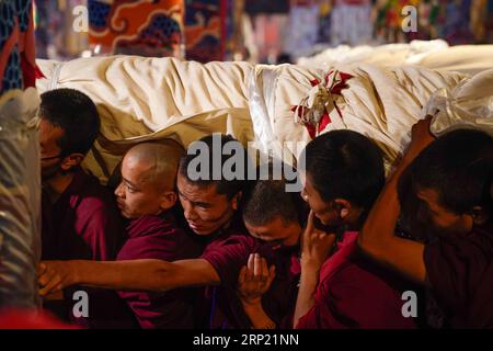 (180811) -- LHASSA, 11 août 2018 -- des gens portent une immense peinture Thangka au monastère de Drepung à Lhassa, capitale de la région autonome du Tibet du sud-ouest de la Chine, 11 août 2018. Les célébrations du traditionnel festival de Shoton, ou festival du yaourt, ont commencé à Lhassa samedi. Cette année, l'événement mettra en vedette le soleil traditionnel des cérémonies du Bouddha, avec d'énormes peintures Thangka portant l'image du Bouddha exposées sur les collines près des monastères de Drepung et de sera, ainsi que des spectacles d'opéra tibétain, des spectacles d'équitation et un spectacle de costumes ethniques.) (ZYD) CHINE-TIBET-SHOTON FE Banque D'Images