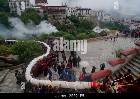 (180811) -- LHASSA, 11 août 2018 -- des gens portent une énorme peinture Thangka au monastère de Drepung à Lhassa, capitale de la région autonome du Tibet du sud-ouest de la Chine, 11 août 2018. Les célébrations du traditionnel festival de Shoton, ou festival du yaourt, ont commencé à Lhassa samedi. Cette année, l'événement mettra en vedette le soleil traditionnel des cérémonies du Bouddha, avec d'énormes peintures Thangka portant l'image du Bouddha exposées sur les collines près des monastères de Drepung et de sera, ainsi que des spectacles d'opéra tibétain, des spectacles d'équitation et un spectacle de costumes ethniques.) (ZYD) CHINE-TIBET-SHOTON FE Banque D'Images