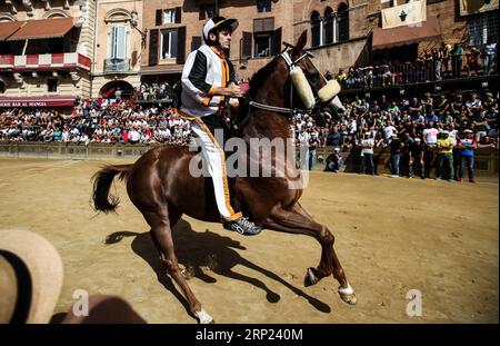 (180816) -- SIENNE, 16 août 2018 (Xinhua) -- Un jockey monte son cheval pendant le troisième jour d'épreuve de la course hippique à Sienne, Italie, le 15 août 2018. Une course hippique traditionnelle, connue sous le nom de Palio di Siena en italien, est organisée dans la ville historique italienne de Sienne, attirant des dizaines de milliers de spectateurs. La course de chevaux à Sienne remonte à la période médiévale et a lieu le 2 juillet et le 16 août de chaque année. Des essais de trois jours ont lieu avant la course finale. (Xinhua/Jin Yu) (SP)ITALY-SIENA-PALIO PUBLICATIONxNOTxINxCHN Banque D'Images