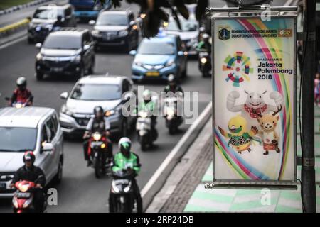 (180817) -- JAKARTA, août 17,2018 -- les motocyclistes passent devant un panneau d'affichage des Jeux asiatiques dans la rue de Jakarta le 14 août 2018. Le 18 août sera marqué par la cérémonie d'ouverture des 18e Jeux asiatiques à Jakarta, Indonésie. INDONÉSIE-JAKARTA-JEUX ASIATIQUES-VIE QUOTIDIENNE PANXYULONG PUBLICATIONXNOTXINXCHN Banque D'Images