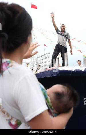 (180817) -- YANGJIANG, 17 août 2018 -- Une femme tenant son enfant fait ses adieux à un membre de sa famille qui met les voiles pour la pêche à Yangjiang, dans la province du Guangdong du sud de la Chine, le 17 août 2018. En raison de l'influence du typhon Bebinca, la levée de l'interdiction de pêche dans le Guangdong a été reportée au 17 août. ) (Zwx) CHINA-GUANGDONG-FISHING BAN-END (CN) ZhangxJiayang PUBLICATIONxNOTxINxCHN Banque D'Images