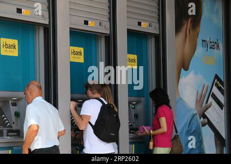 (180820) -- ATHÈNES, 20 août 2018 -- des gens se tiennent devant les guichets automatiques à Athènes, Grèce, 20 août 2018. La sortie lundi de la Grèce des programmes de renflouement introduits il y a huit ans pour éviter un effondrement financier et restaurer la croissance de l'économie endettée est un premier pas important, mais aucune raison de célébrer, a déclaré à Xinhua l'ancien Premier ministre grec George Papandreou. (wtc) GRÈCE-ATHÈNES-SORTIE DES RENFLOUEMENTS MariosxLolos PUBLICATIONxNOTxINxCHN Banque D'Images