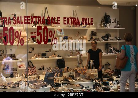 (180823) -- ATHÈNES, 23 août 2018 -- Une femme regarde des marchandises devant des vitrines pendant la période des soldes d'été à Athènes, Grèce, le 22 août 2018. La distribution grecque a accueilli lundi le jalon de la sortie de la Grèce des programmes internationaux de financement du sauvetage avec des sentiments mitigés d optimisme et de préoccupation pour l avenir. POUR ALLER AVEC l'article : la distribution grecque accueille avec optimisme la fin des renflouements, souci pour l'avenir ) (zxj) GRÈCE-ATHÈNES-RENFLOUEMENT SORTIE-MARCHÉ MariosxLolos PUBLICATIONxNOTxINxCHN Banque D'Images