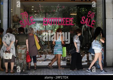 (180823) -- ATHÈNES, 23 août 2018 -- les gens regardent les marchandises devant les vitrines pendant la période des soldes d'été à Athènes, Grèce, le 22 août 2018. La distribution grecque a accueilli lundi le jalon de la sortie de la Grèce des programmes internationaux de financement du sauvetage avec des sentiments mitigés d optimisme et de préoccupation pour l avenir. POUR ALLER AVEC l'article : la distribution grecque accueille avec optimisme la fin des renflouements, souci pour l'avenir ) (zxj) GRÈCE-ATHÈNES-RENFLOUEMENT SORTIE-MARCHÉ MariosxLolos PUBLICATIONxNOTxINxCHN Banque D'Images