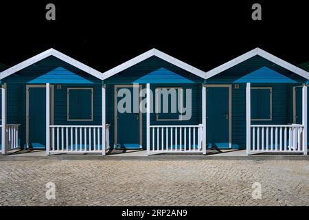 Plusieurs cabanes de pêcheurs se tiennent côte à côte sur la plage d'Olhos de Agua, un ancien village de pêcheurs de l'Algarve portugaise dans le district de Banque D'Images