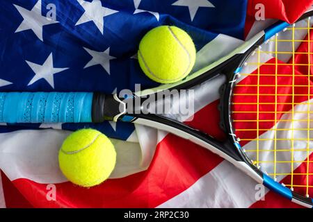 Compétition de tennis aux États-Unis. Composition sportive avec balles de tennis jaunes, raquette rouge et drapeau de l'Amérique sur fond vert. NOUS sommes ouverts. Pose à plat Banque D'Images