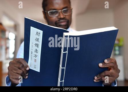 (180831) -- KUNMING, 31 août 2018 -- Diarra lit un livre de médecine traditionnelle chinoise chez elle à Kunming, dans la province du Yunnan du sud-ouest de la Chine, 28 août 2018. Diarra Boubacar, née en 1964 au Mali en Afrique, est docteur en médecine traditionnelle chinoise (MTC). Il est venu étudier en Chine en 1984 et a obtenu un diplôme de docteur en médecine traditionnelle chinoise. Depuis lors, il a passé des années à voyager dans des régions montagneuses reculées du Yunnan, sud-ouest de la Chine, et à aider les villageois locaux à résoudre leurs problèmes de santé. Il a également collecté des fournitures pour les familles aux prises avec la pauvreté. Diarra a dit qu'il a été grandement inspiré par l'équipe médicale chinoise en A. Banque D'Images