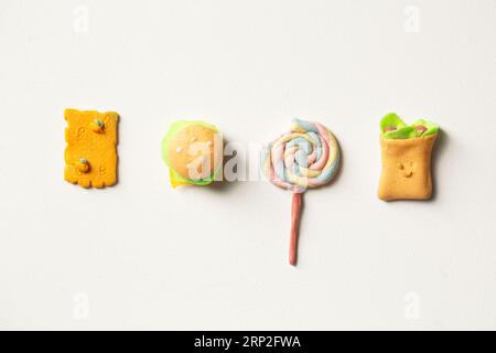 Œuvres pour enfants sous forme de nourriture avec de la plasticine sur fond blanc Banque D'Images