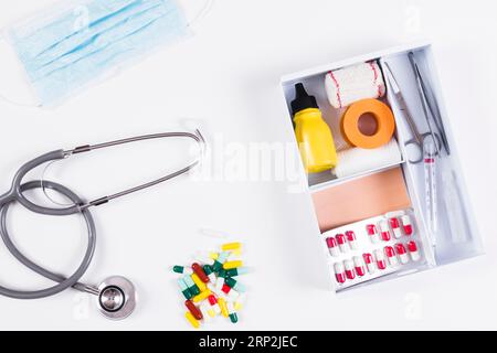 Capsules colorées masque stéthoscope avec kits de premiers soins fond blanc Banque D'Images