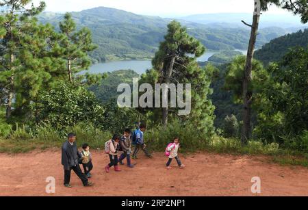 (180908) -- KUNMING, 8 septembre 2018 -- Wang Zhengxiang renvoie des élèves chez eux après l'école dans le village de Sanmeng de Luquan Yi et le comté autonome de Miao, dans la province du Yunnan au sud-ouest de la Chine, le 5 septembre 2018. Un enseignant, huit étudiants, aucun n’a été et ne sera abandonné grâce à l’enseignant rural Wang Zhengxiang. Wang Zhengxiang du groupe ethnique Miao, 56 ans, est le seul enseignant et enseigne à l'école primaire du village isolé d'Ayiyang depuis 38 ans. L'école primaire Ayiyang, située à une altitude de 2 600 mètres au-dessus du niveau de la mer et entourée de montagnes, n'est pas facilement accessible du monde extérieur. Le Banque D'Images